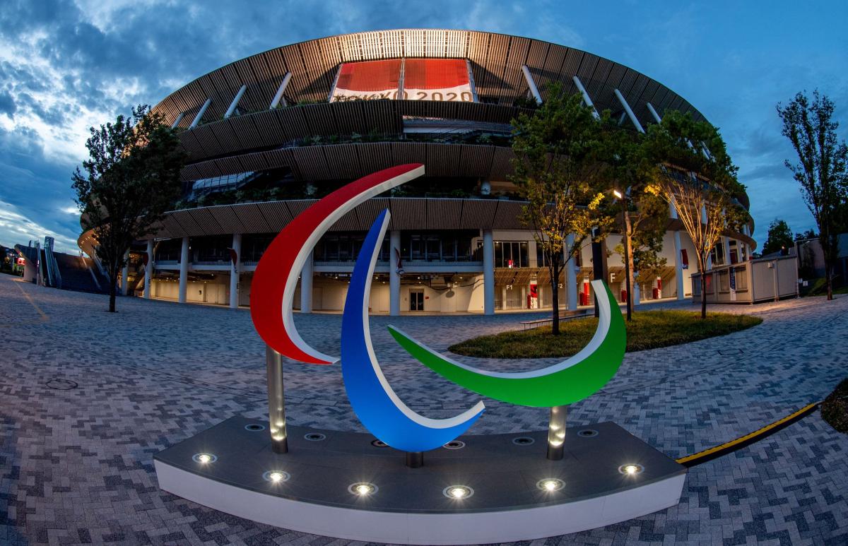 The Agitos sign in front of the Tokyo Stadium at dusk.