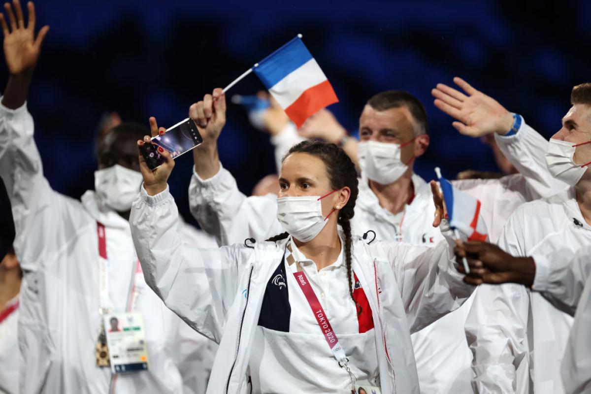 French athletes wave small flags during the athletes' parade at the Tokyo 2020 Opening Ceremony.