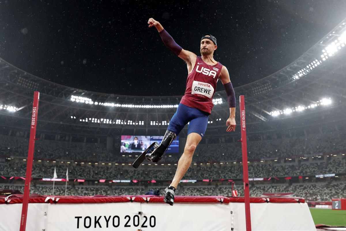 A male high jumper raises his right fist in celebration after winning his event at the Tokyo 2020 Paralympic Games.