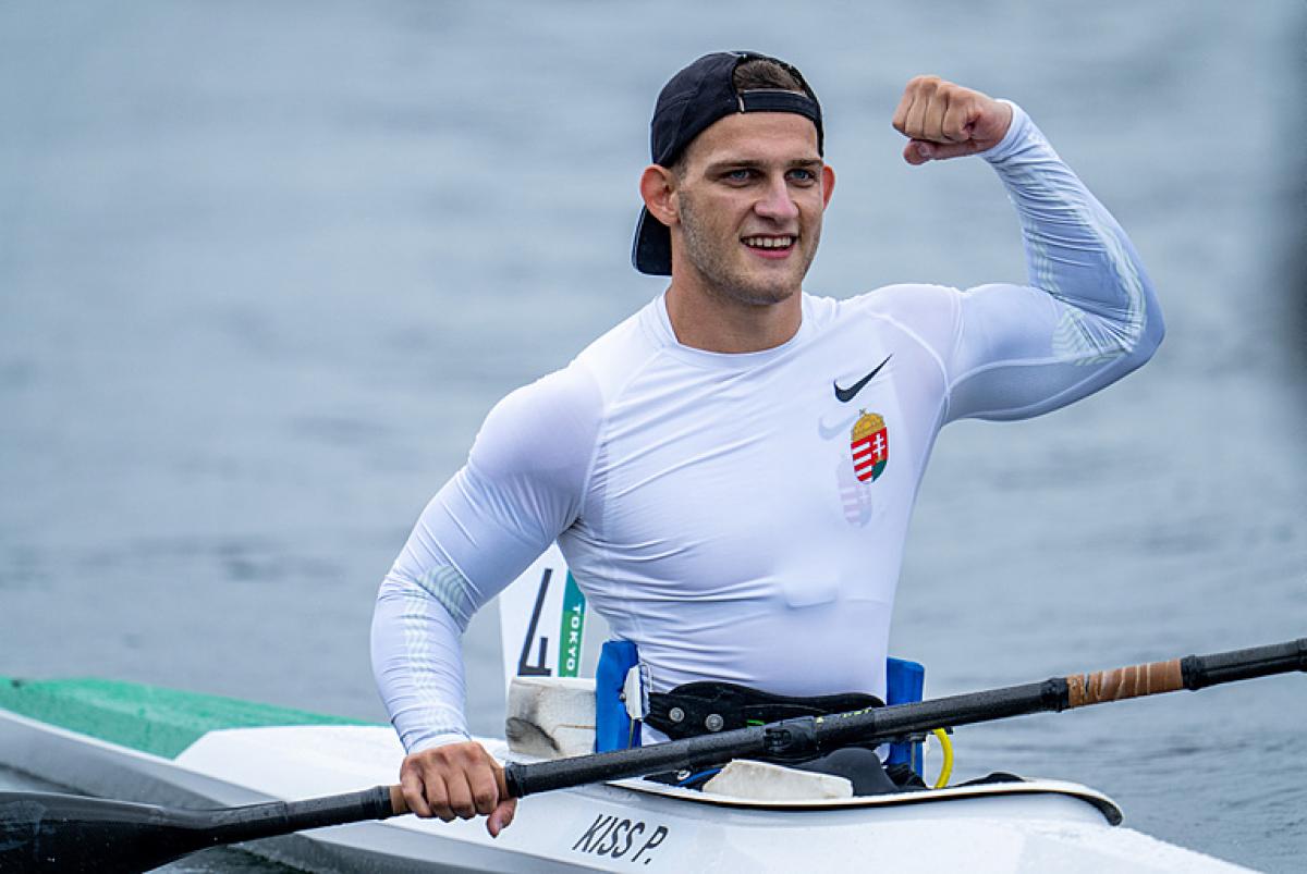 A male athlete in a kayak pumps his fist