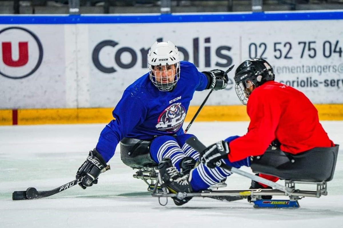 Two male Para ice hockey players competing on ice