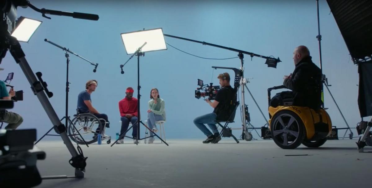 A male athlete on a wheelchair is filmed by a production crew