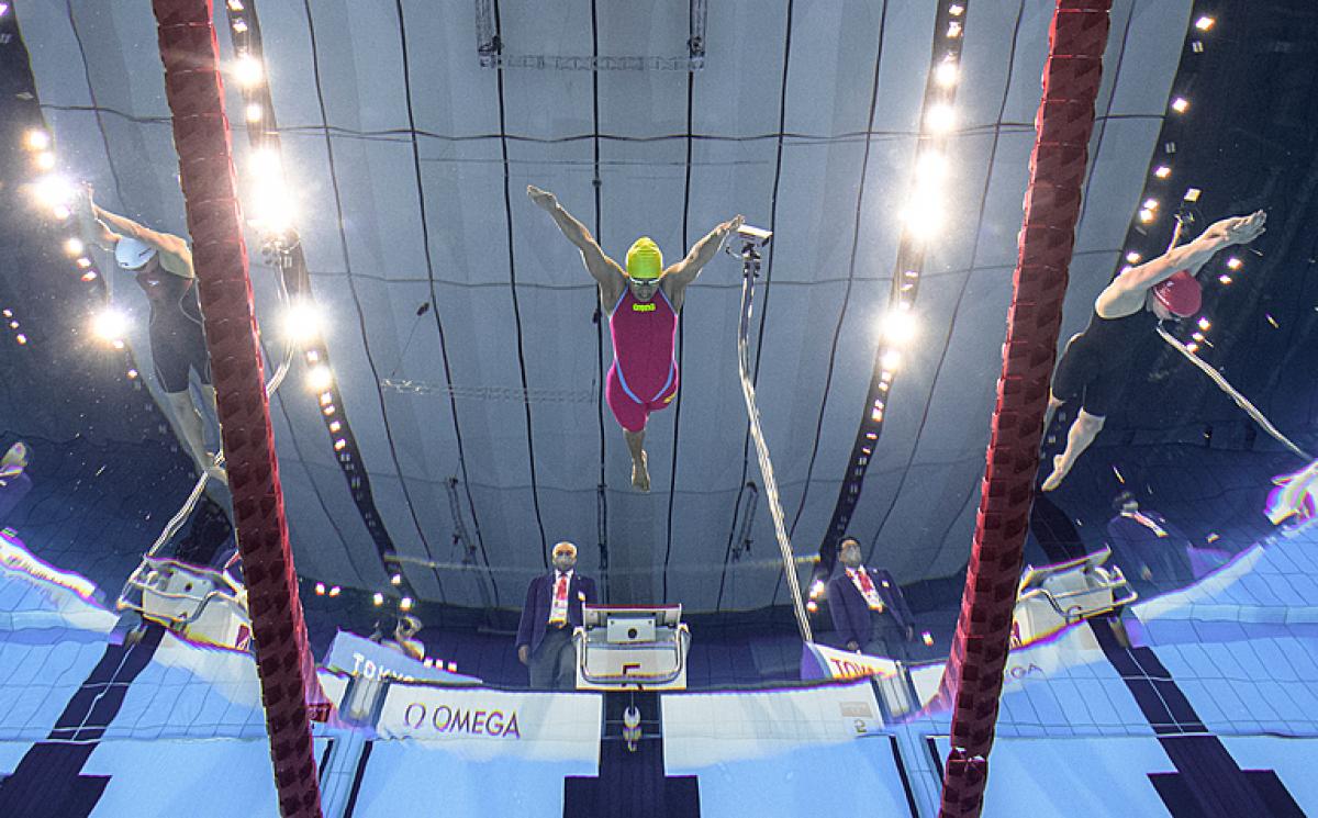 An underwater image of three female Para swimmers jumping in the water at the Tokyo 2020 Paralympic Games