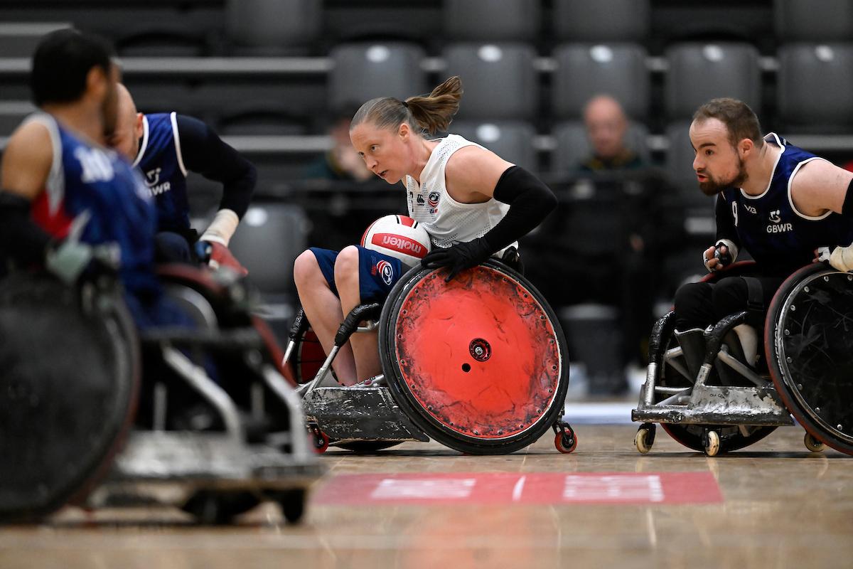 A female wheelchair rugby athlete plays with male players.