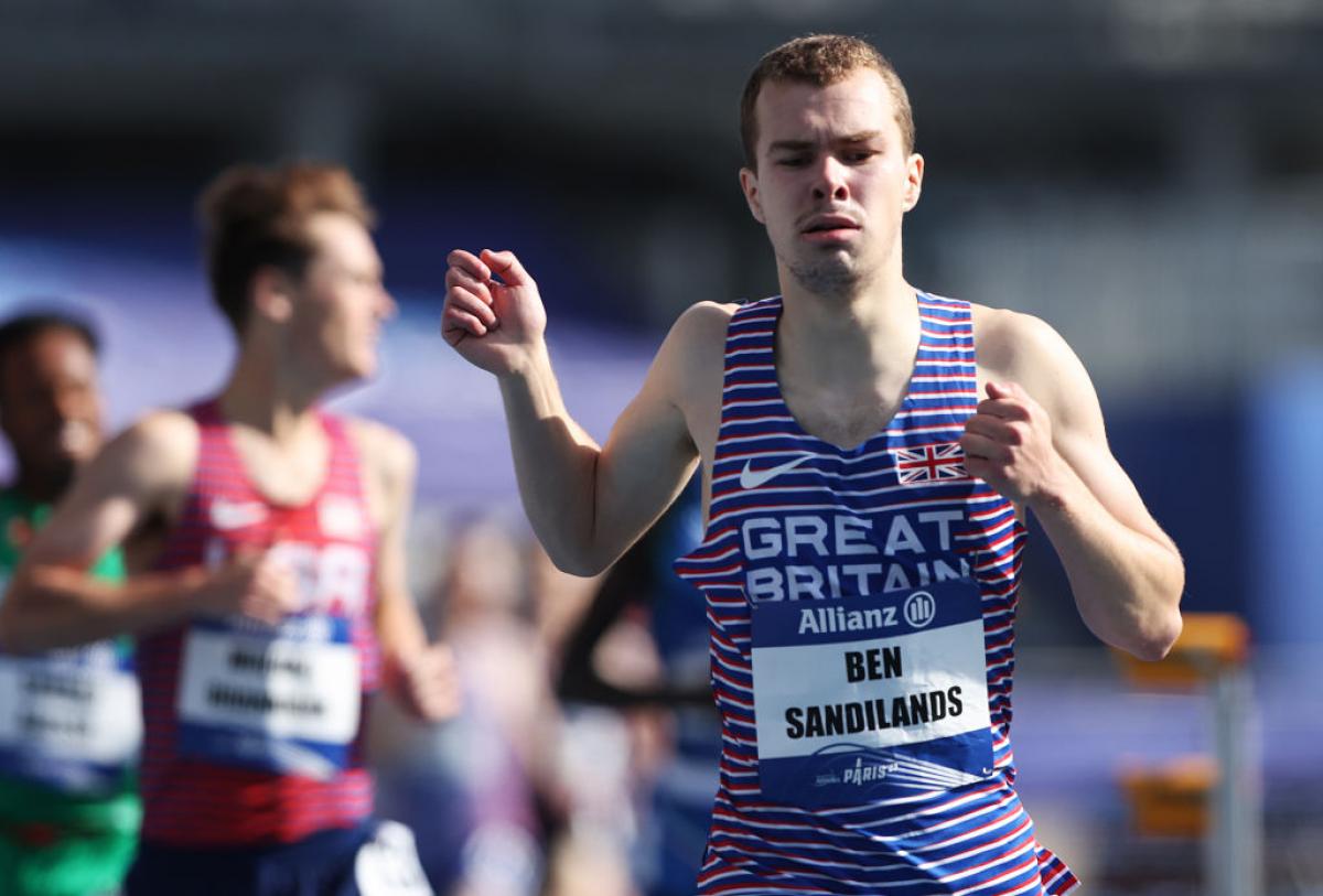 A male runner ahead of other runners in a competition