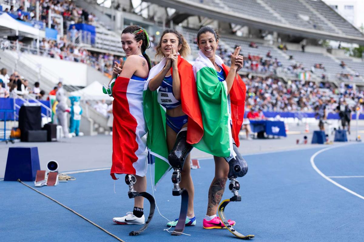 Sportswoman with prosthetic leg smiling while using mobile phone