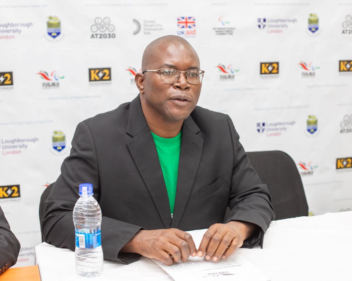 a man in glasses speaking at a press conference 