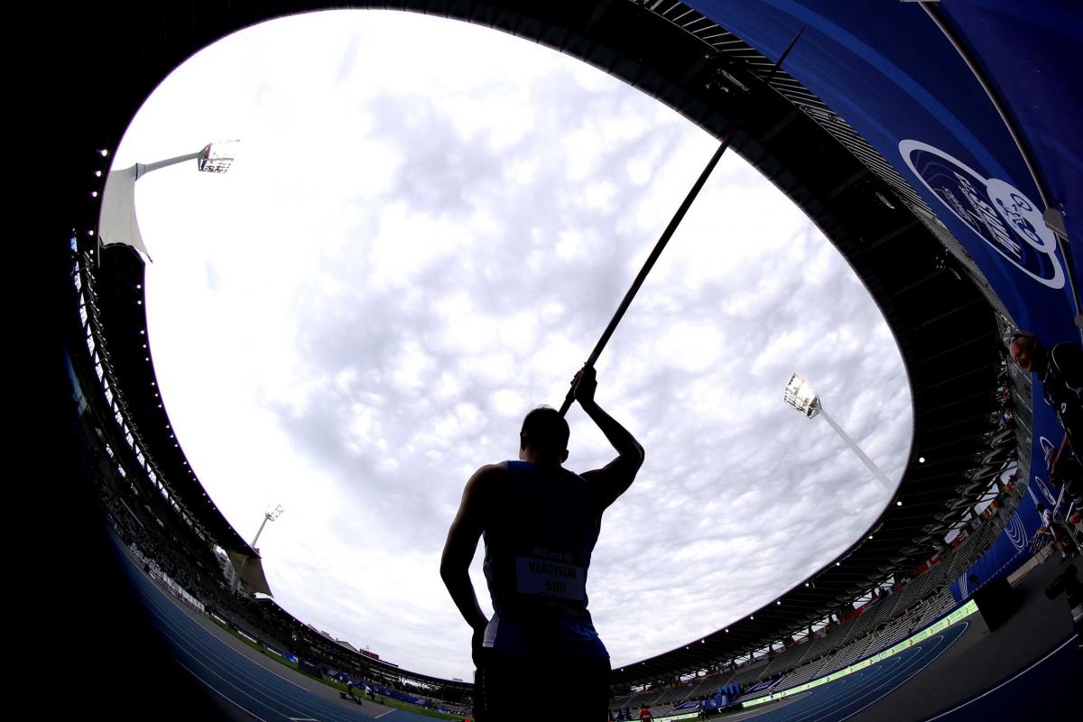 A male javelin thrower in a athletics stadium