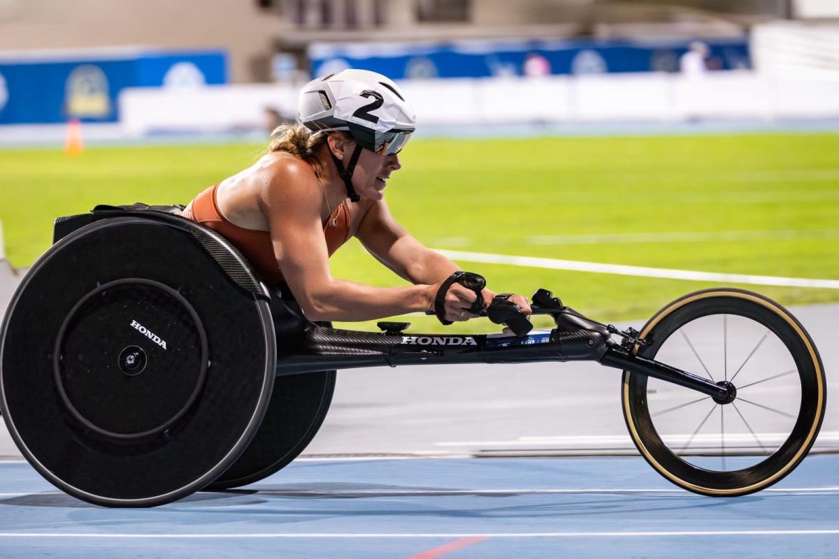 A female wheelchair racer on a blue athletics track