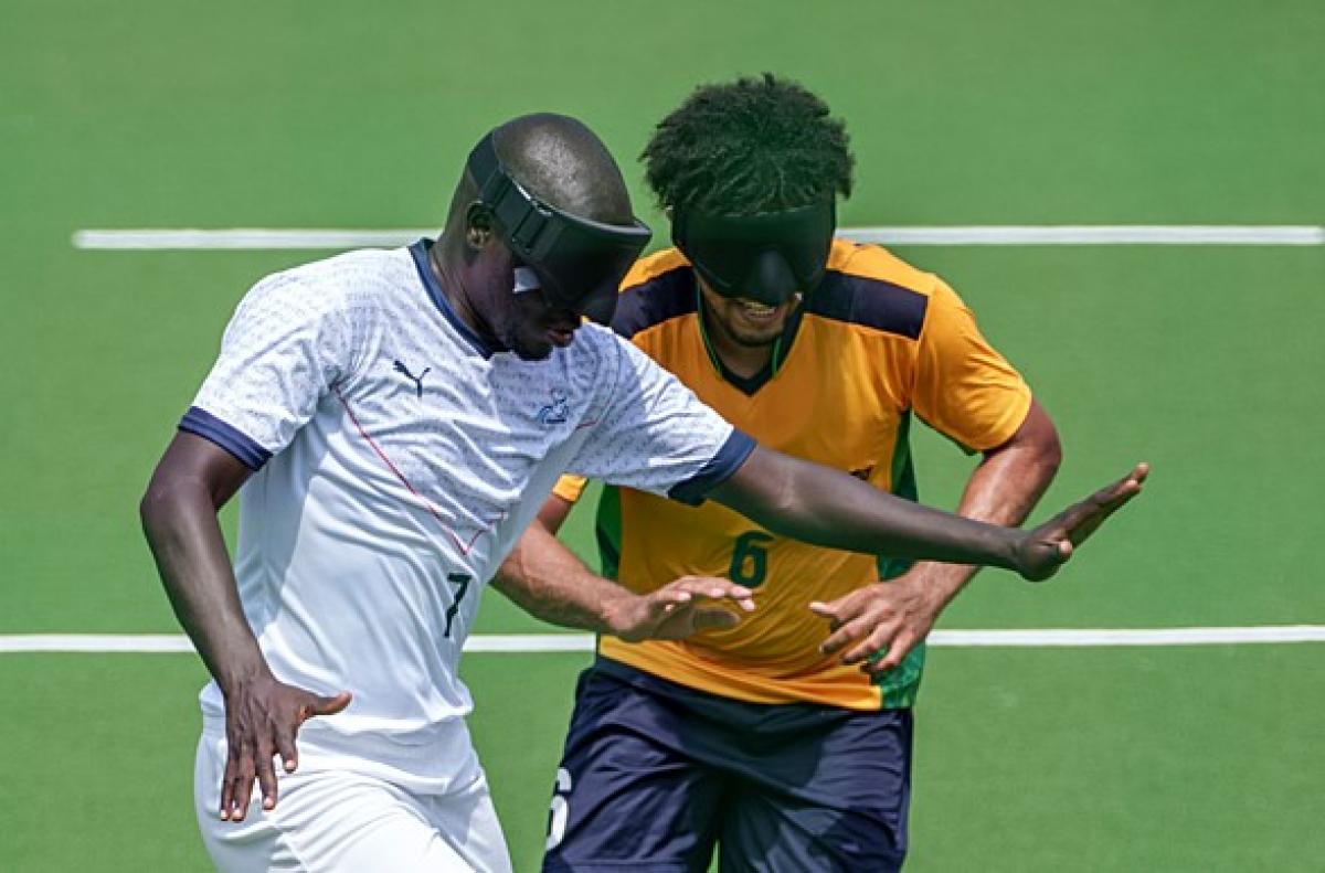 blind footballer Babacar Niang holds off another player from the ball 