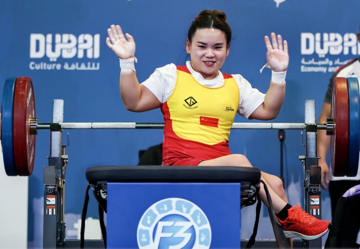 A female powerlifter waving on the bench press