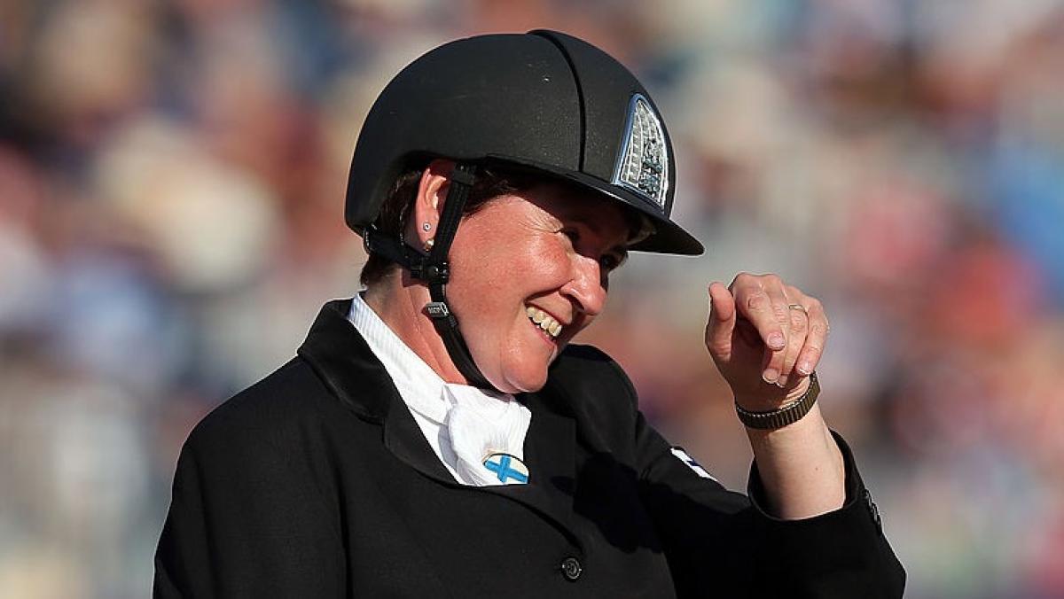 Para equestrian rider Katja Karjalainen smiling and waving on her horse