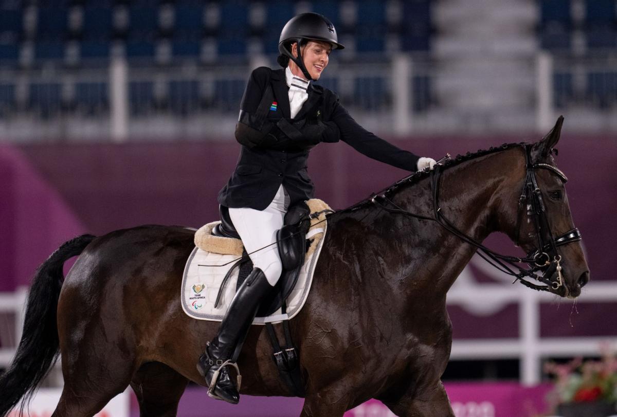 A female Para equestrian athlete rides a horse