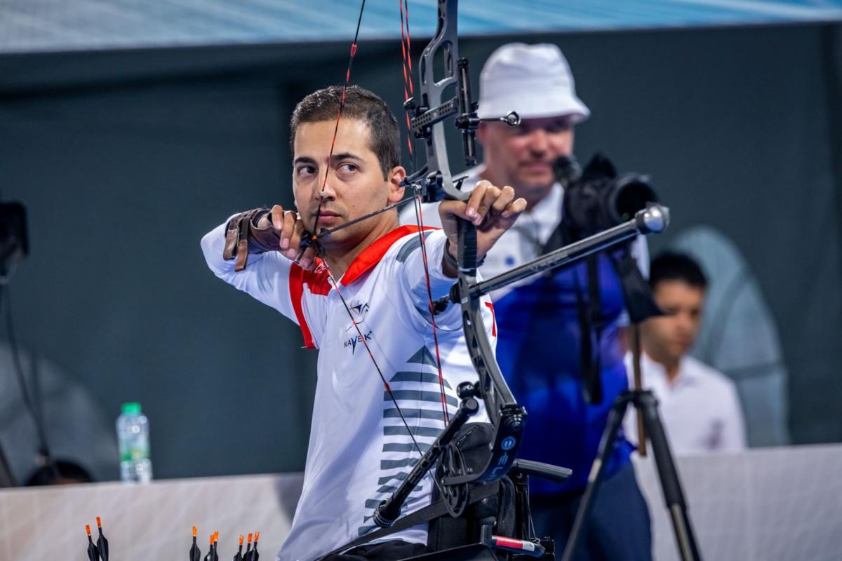 A male Para archer aims at a target during competition