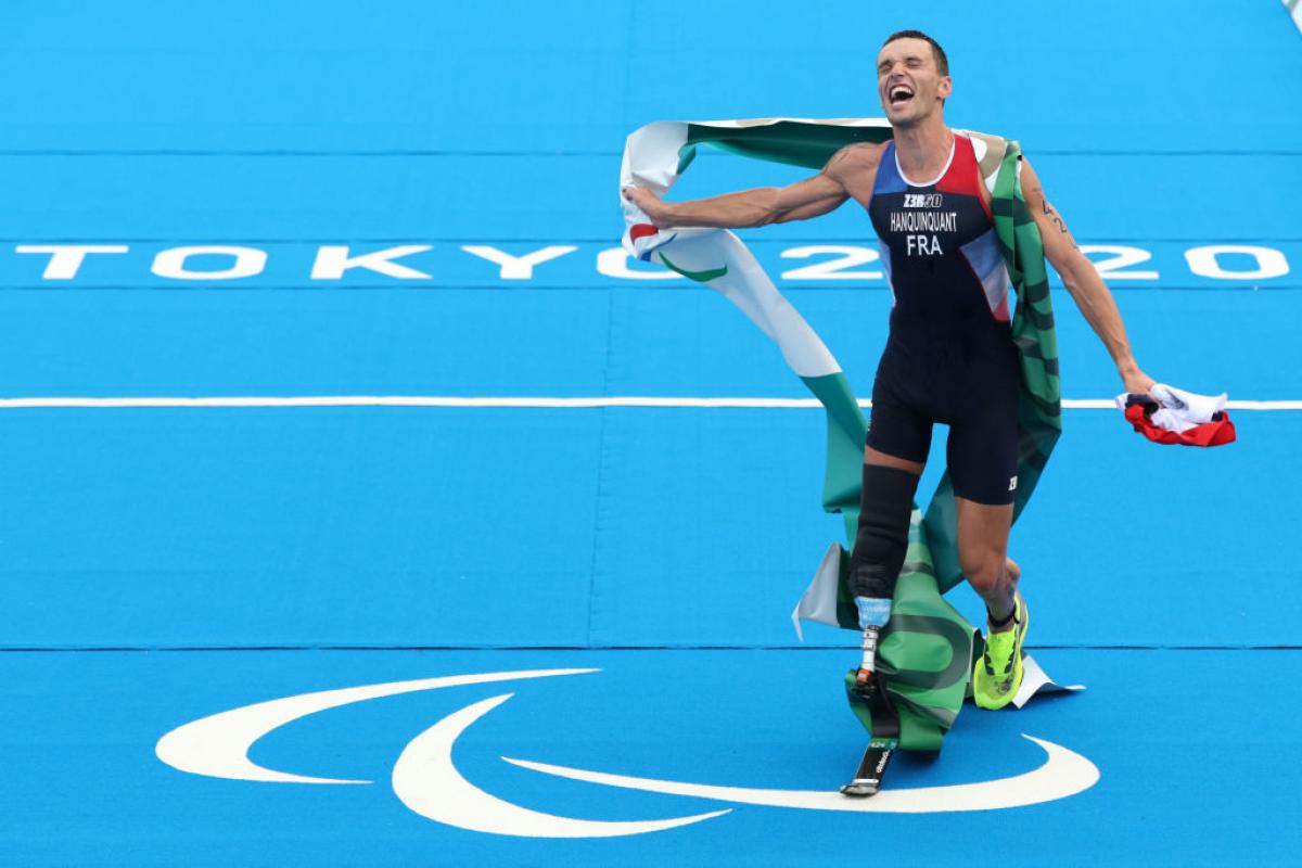 A male triathlete reacts after winning his race at the Tokyo 2020 Paralympics