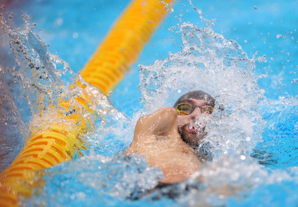 An armless man swimming backstroke