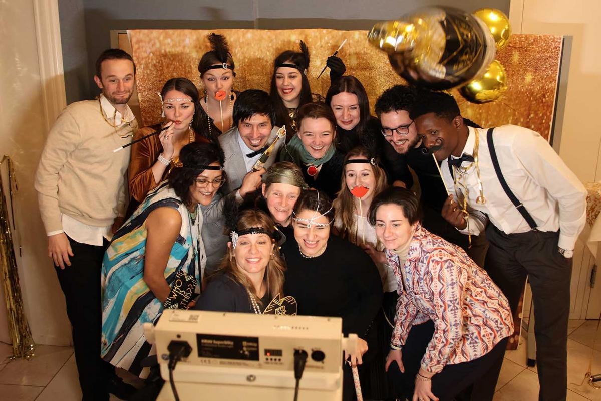 Fourteen IPC employees dressed in 1920s costumes pose for a photo during the IPC winter party in February 2024