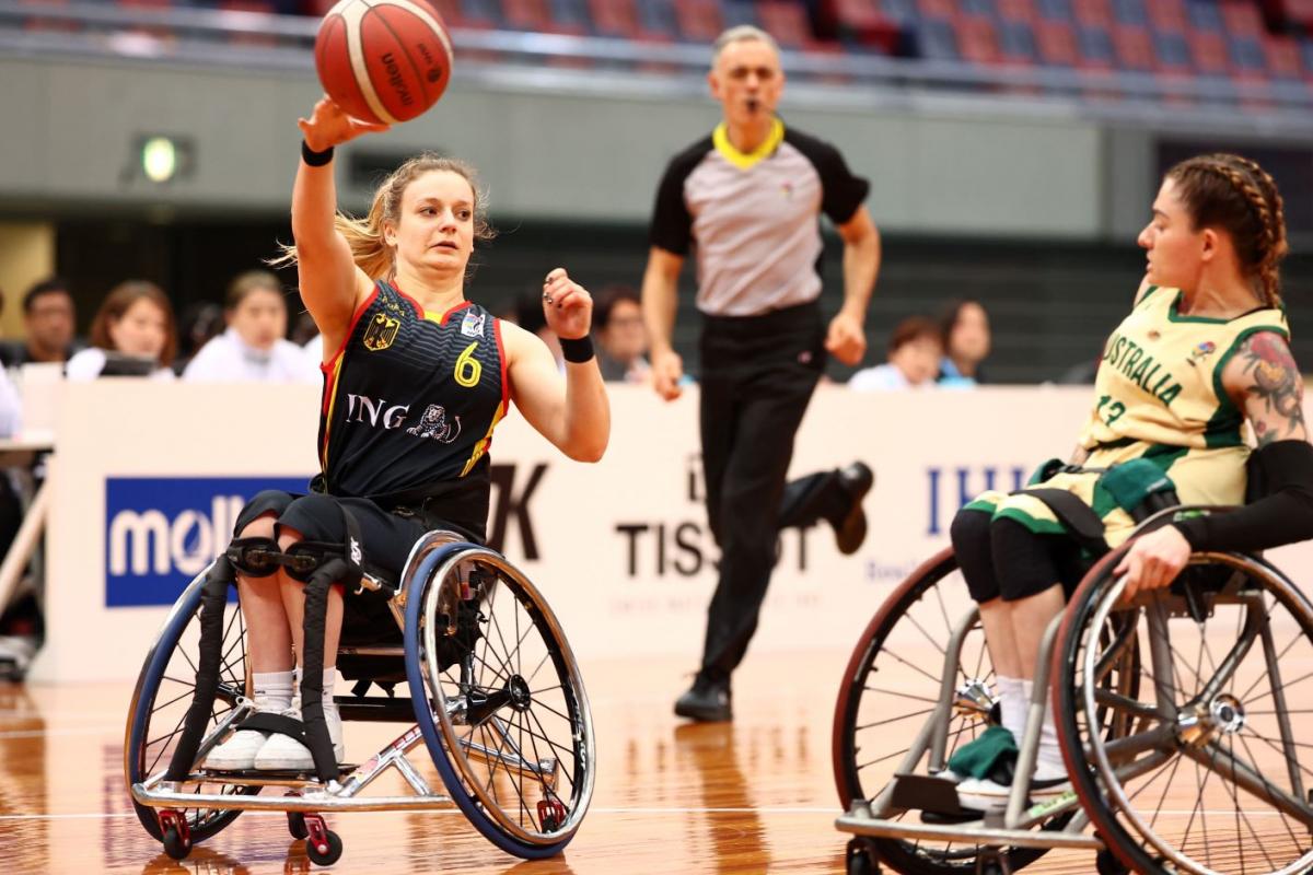 A female wheelchair basketball athlete throws the ball