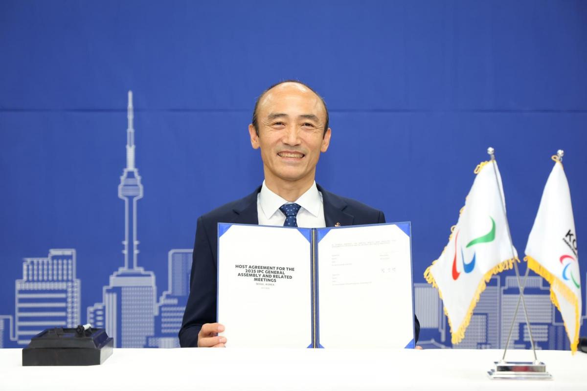 Korea Paralympic Committee President Jin-owan Jung holds a document titled "Host Agreement for the 2025 IPC General Assembly"