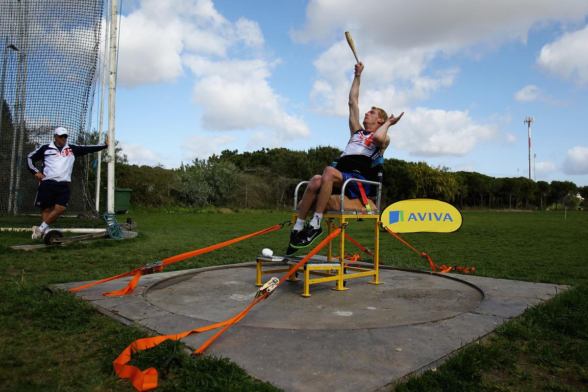 A picture of an athlete sit down throwing an object