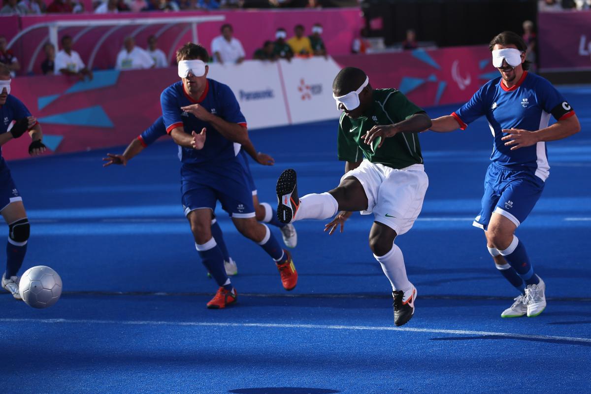 A picture of a blind person shooting the ball in a football match