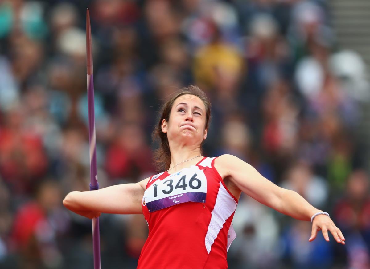 A picture of a woman in the field throwing the Javelin