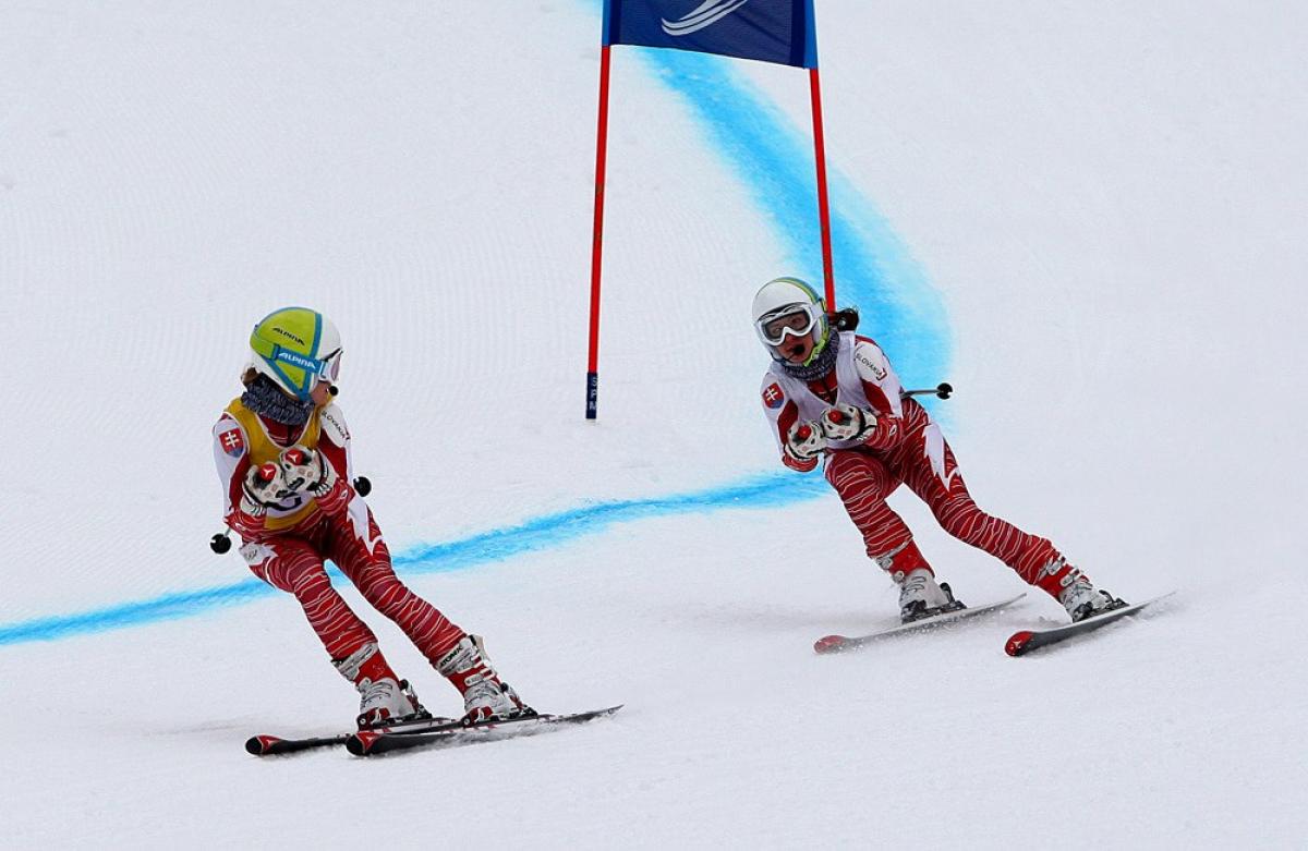 A picture of a blind woman skiing with her guide