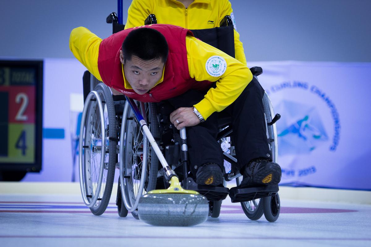 A picture of a man in a wheelchair playing curling