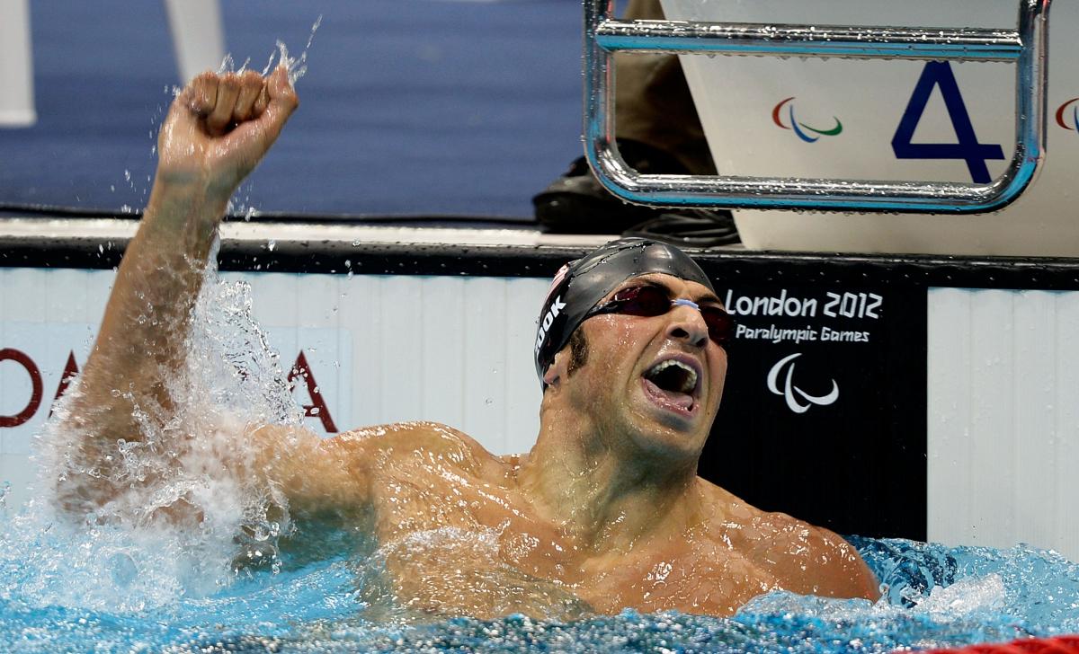 A picture of a man in a pool celebrating his victory