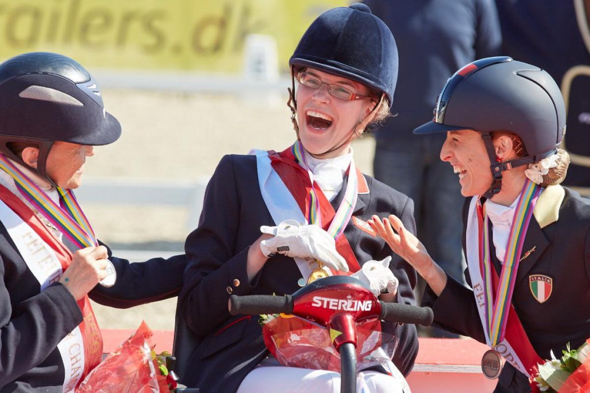 Grade 1a Freestyle gold medallist Sophie Christiansen (GBR), celebrating with compatriot Anne Dunham who took silver and bronze medallist Sara Morganti (ITA), at the JYSK FEI European Para-Dressage Championships in Herning (DEN).