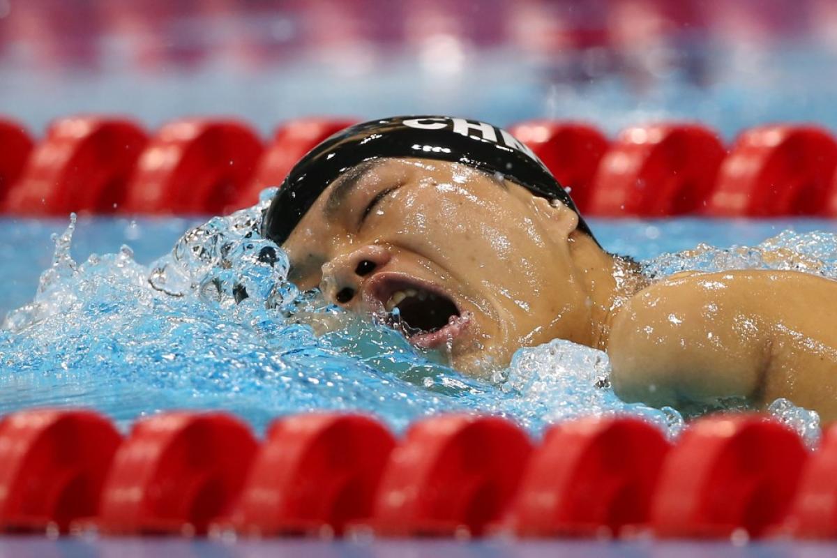 Swimmer in the water breathing between two freestyle strokes