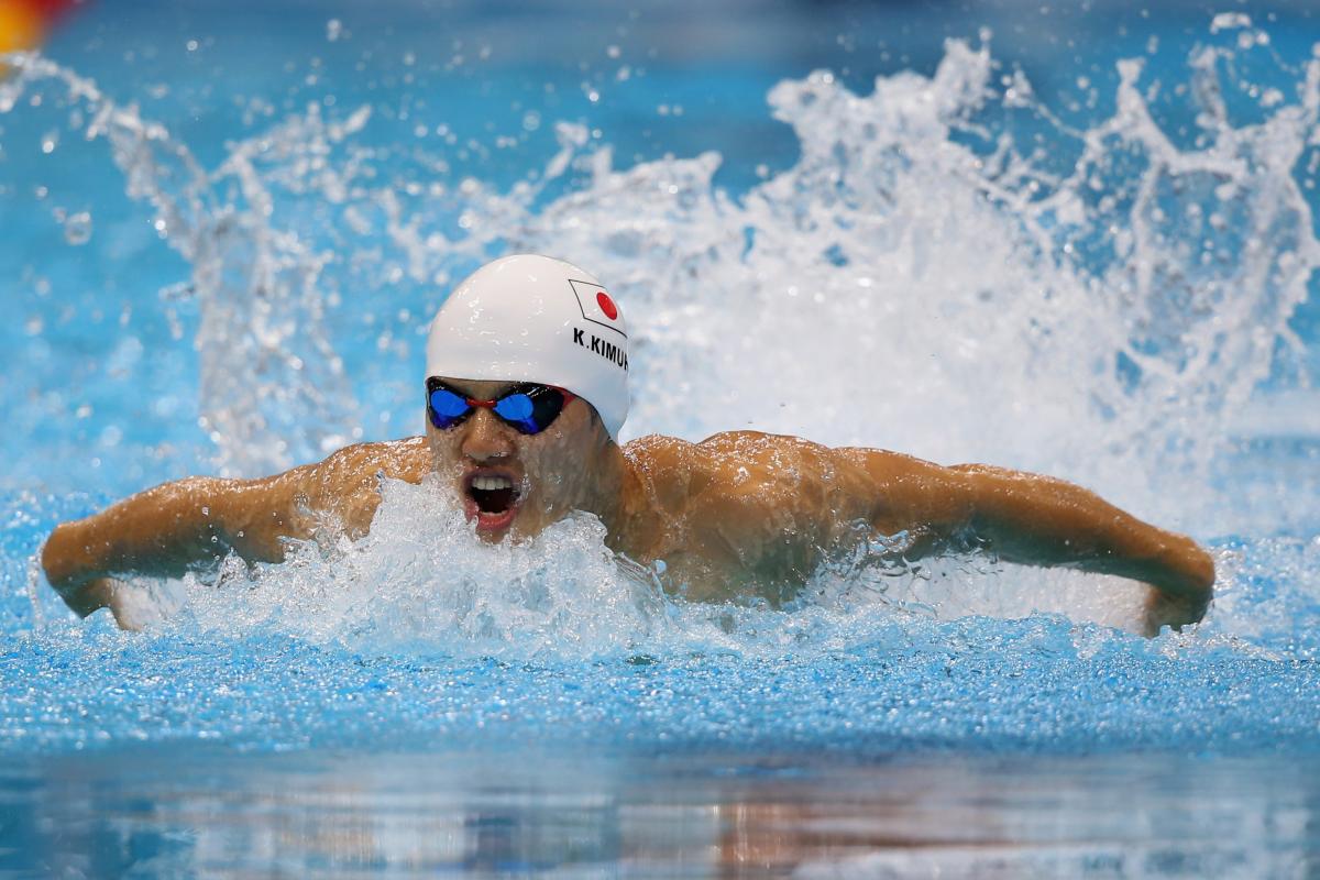 Swimmer in butterfly style in a pool with a simming cap