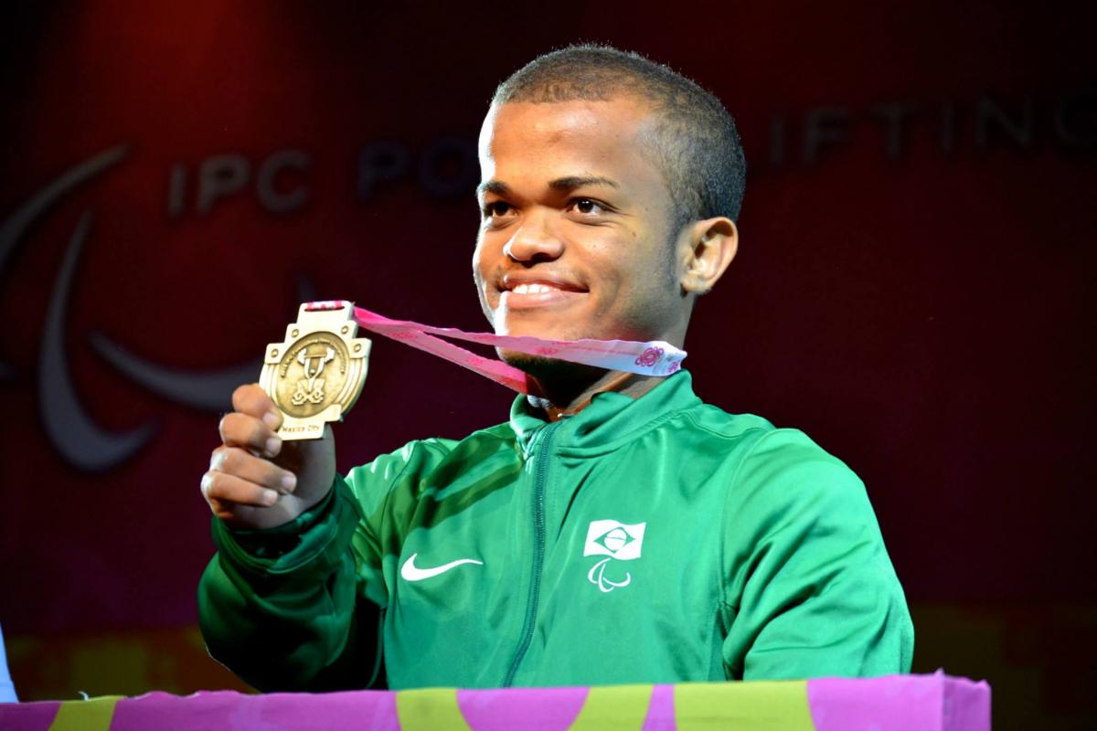 Man smiling, showing his medal