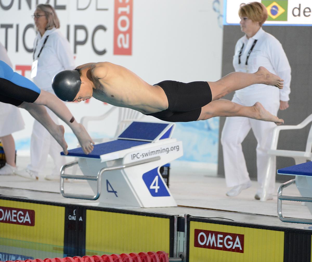 A swimmer without arms begins his race.