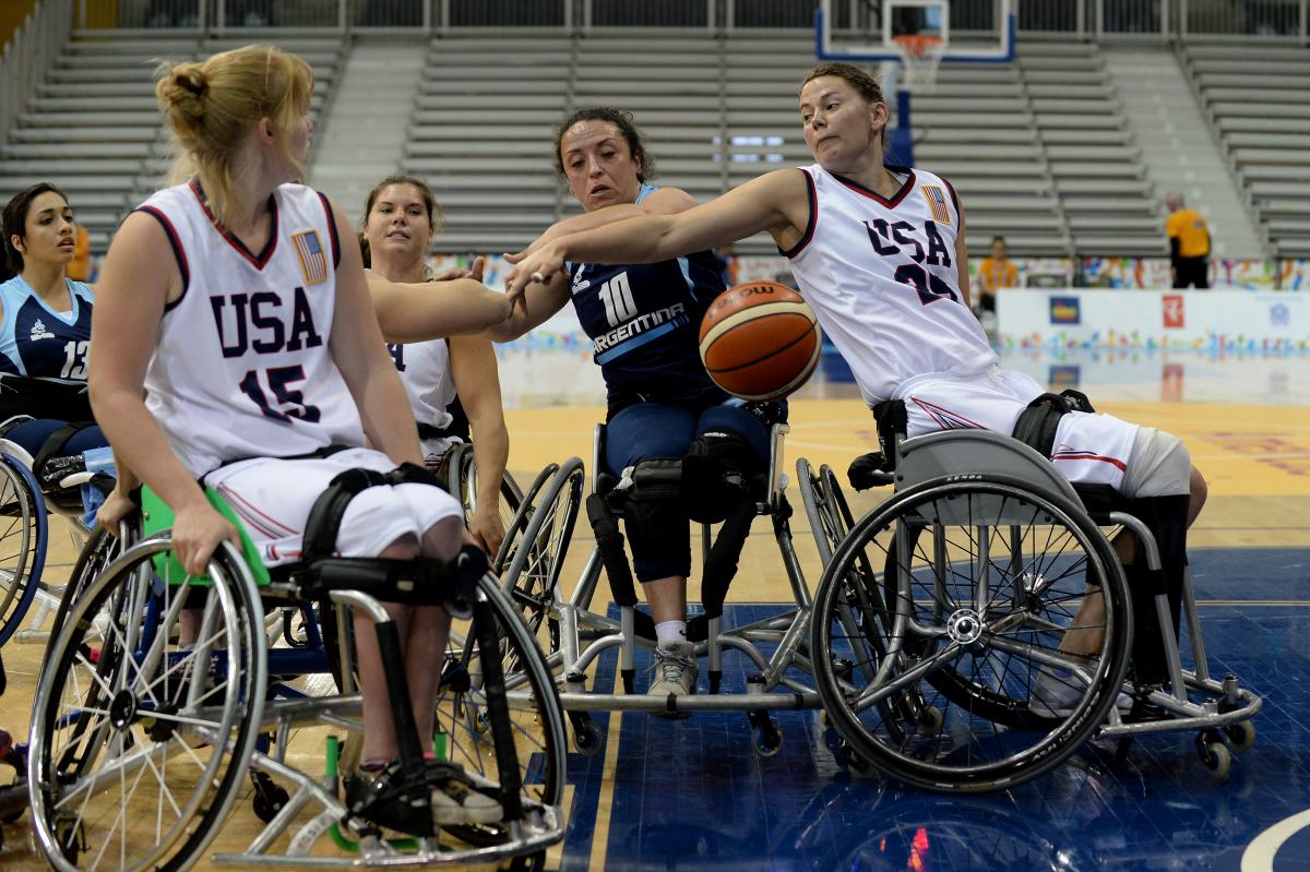 Two women in wheelchairs defending at a basketball game