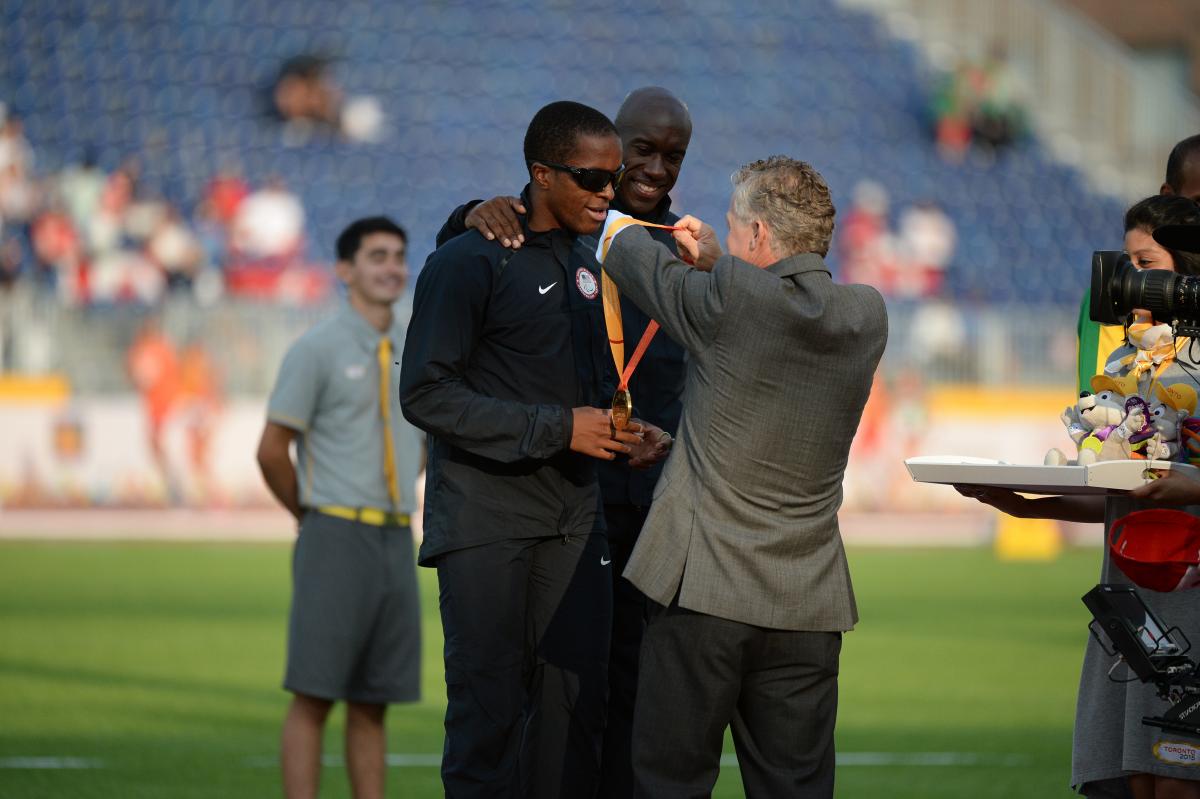 Two men on the podium receiving a medal