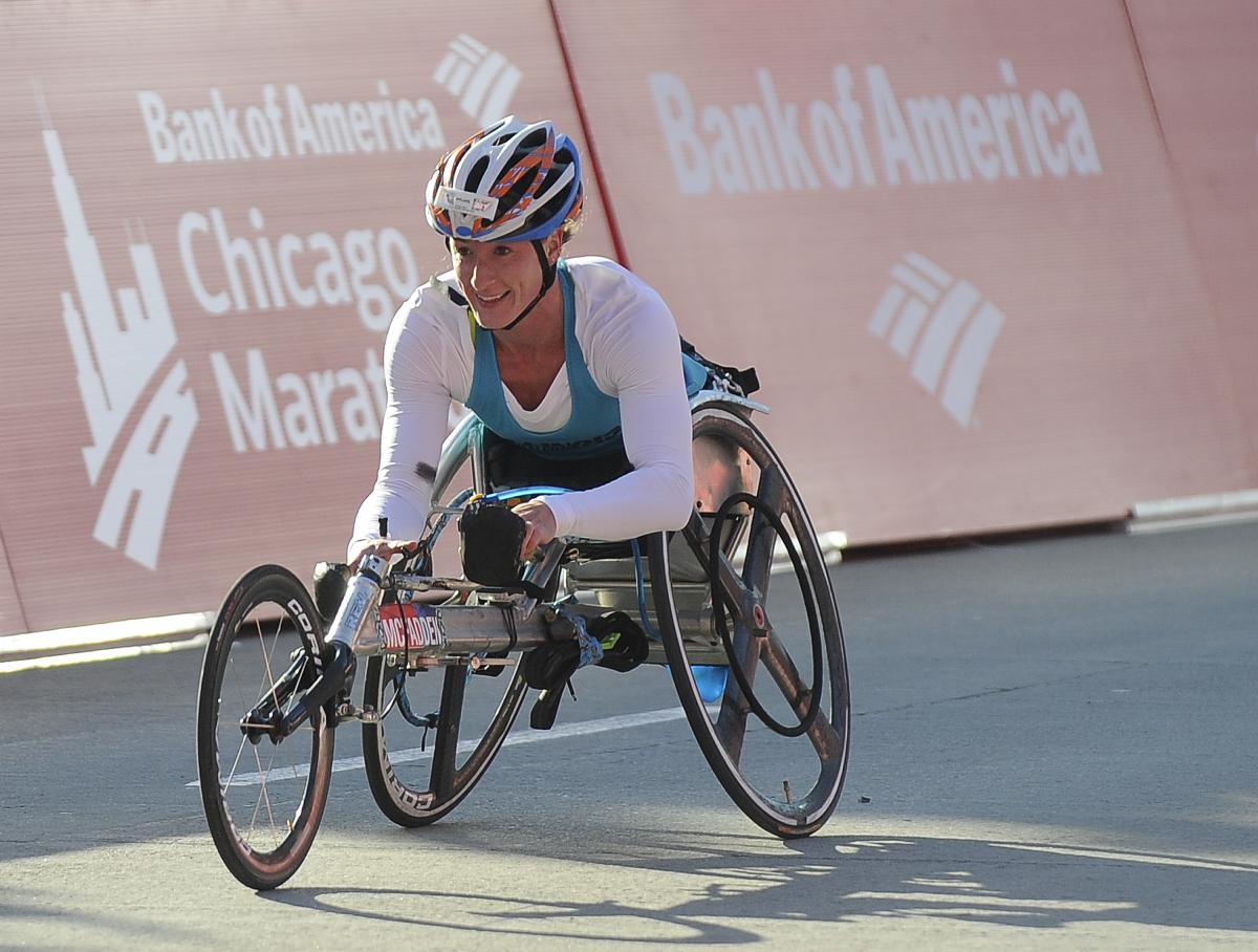 Woman in racing wheelchair, smiling