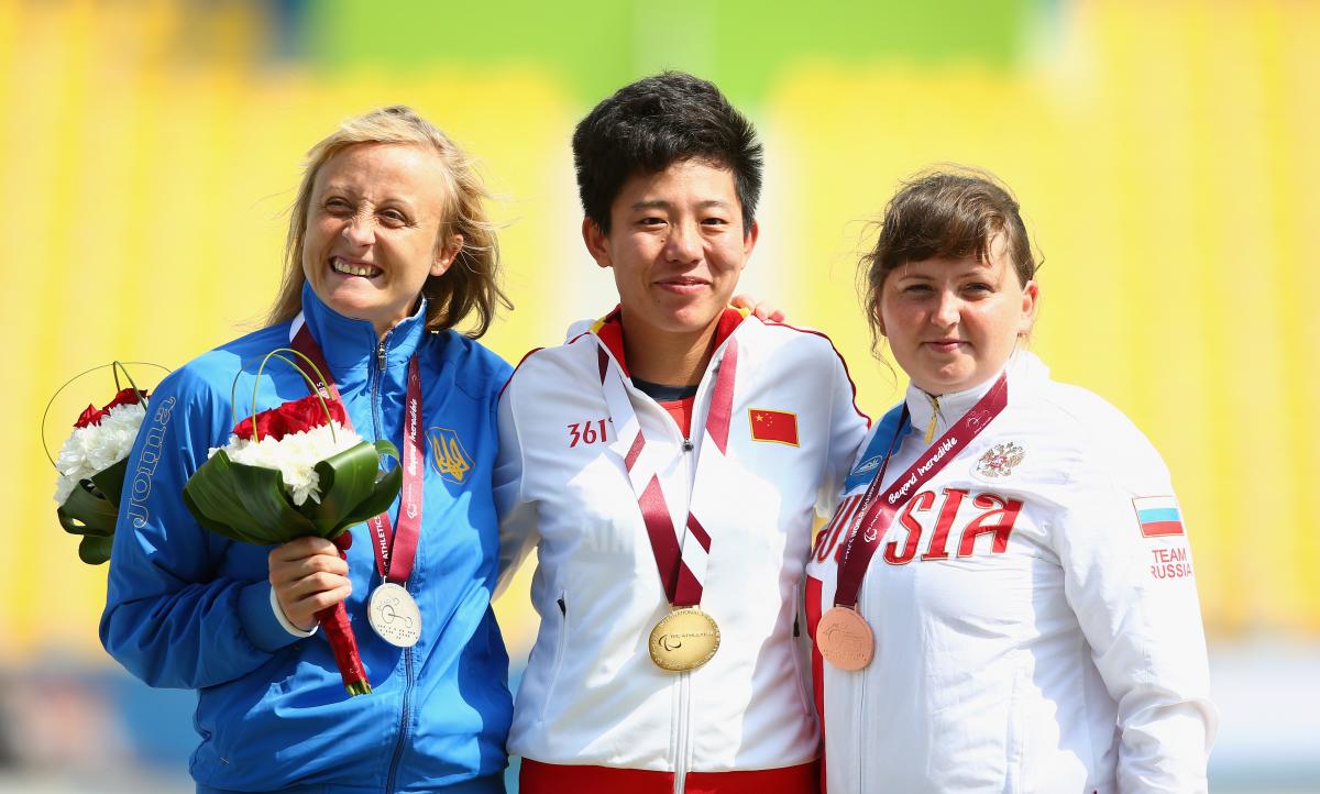 Podium of three women showing their medals