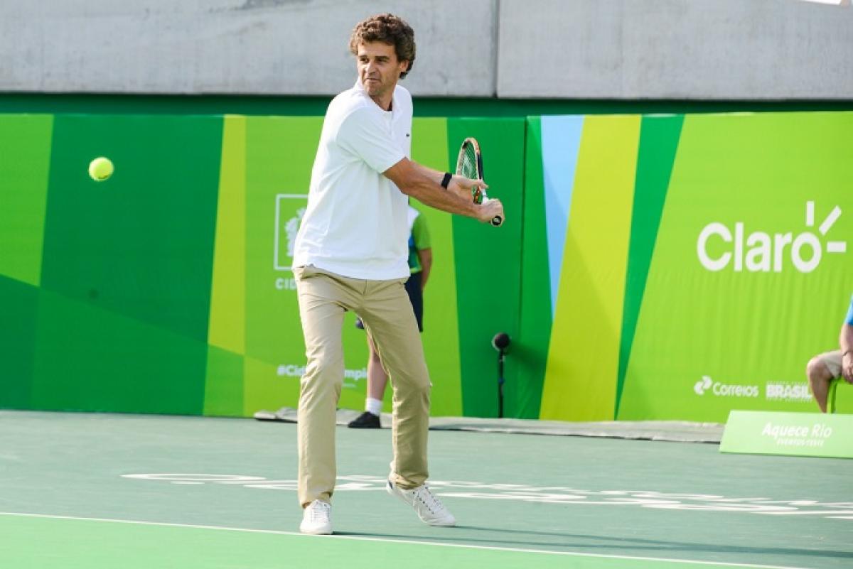 Man holding tennis raquet about to hit the ball