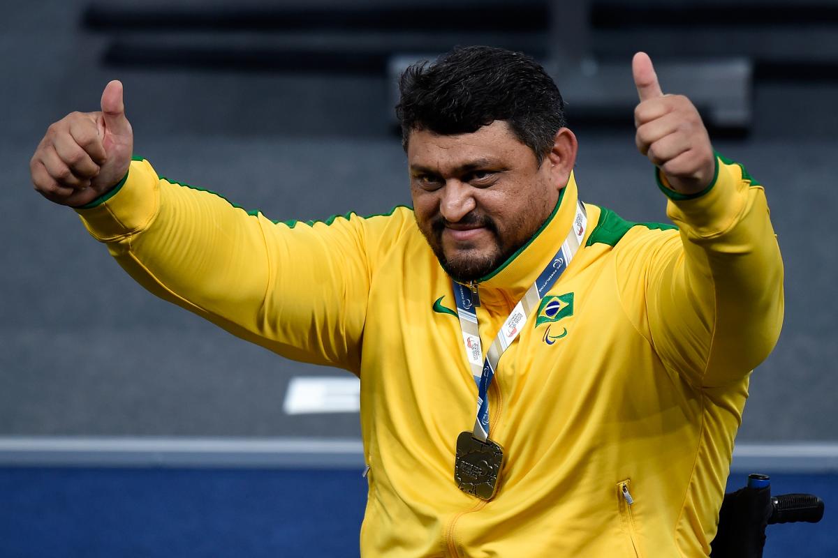 Man in yellow training suit raising his arms