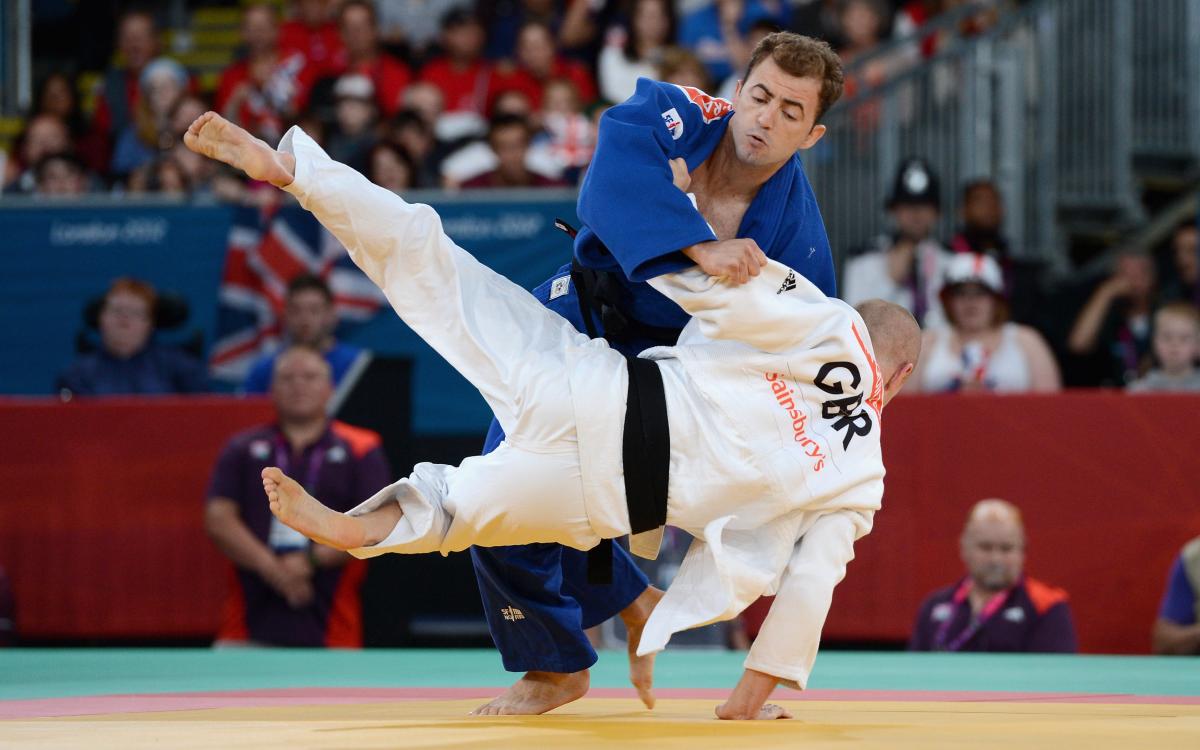 Two judo athletes fighting on a tatami or judo mat. 