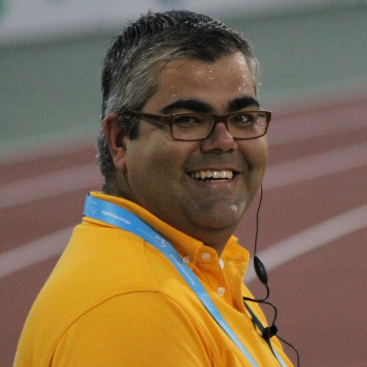 Portrait photo of man, smiling in yellow shirt