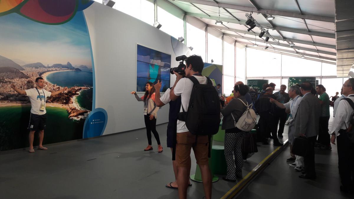 An athletes poses in front of a picture of Rio de Janeiro