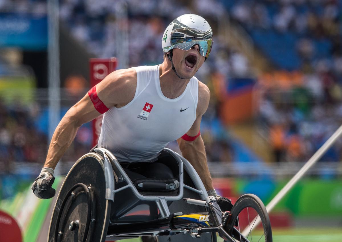 A wheelchair racer celebrates winning gold