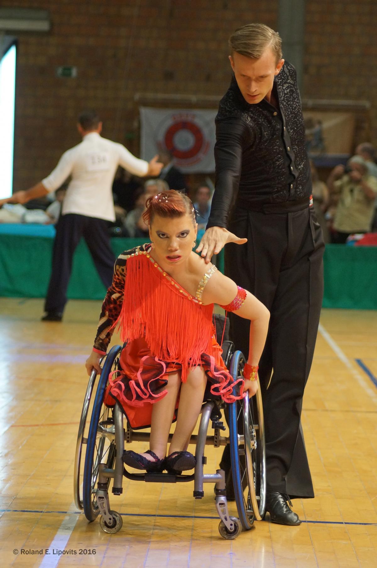 A woman in a wheelchair dances with a standing partner