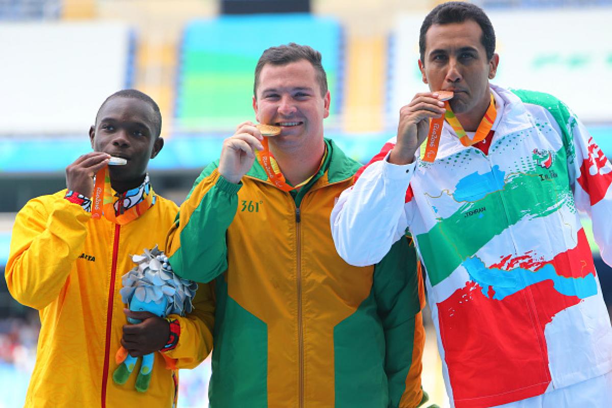 Three men on podium, with their medals