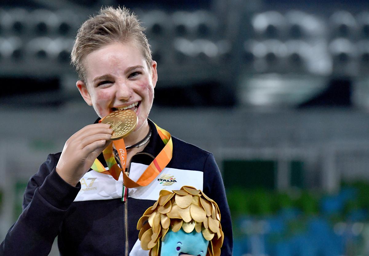 Young woman shows a medal and smiles