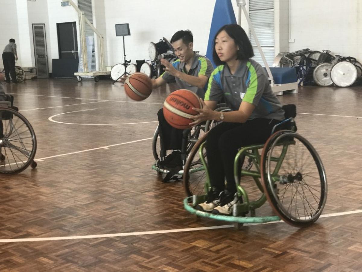 Woman in wheelchair shooting a basketball