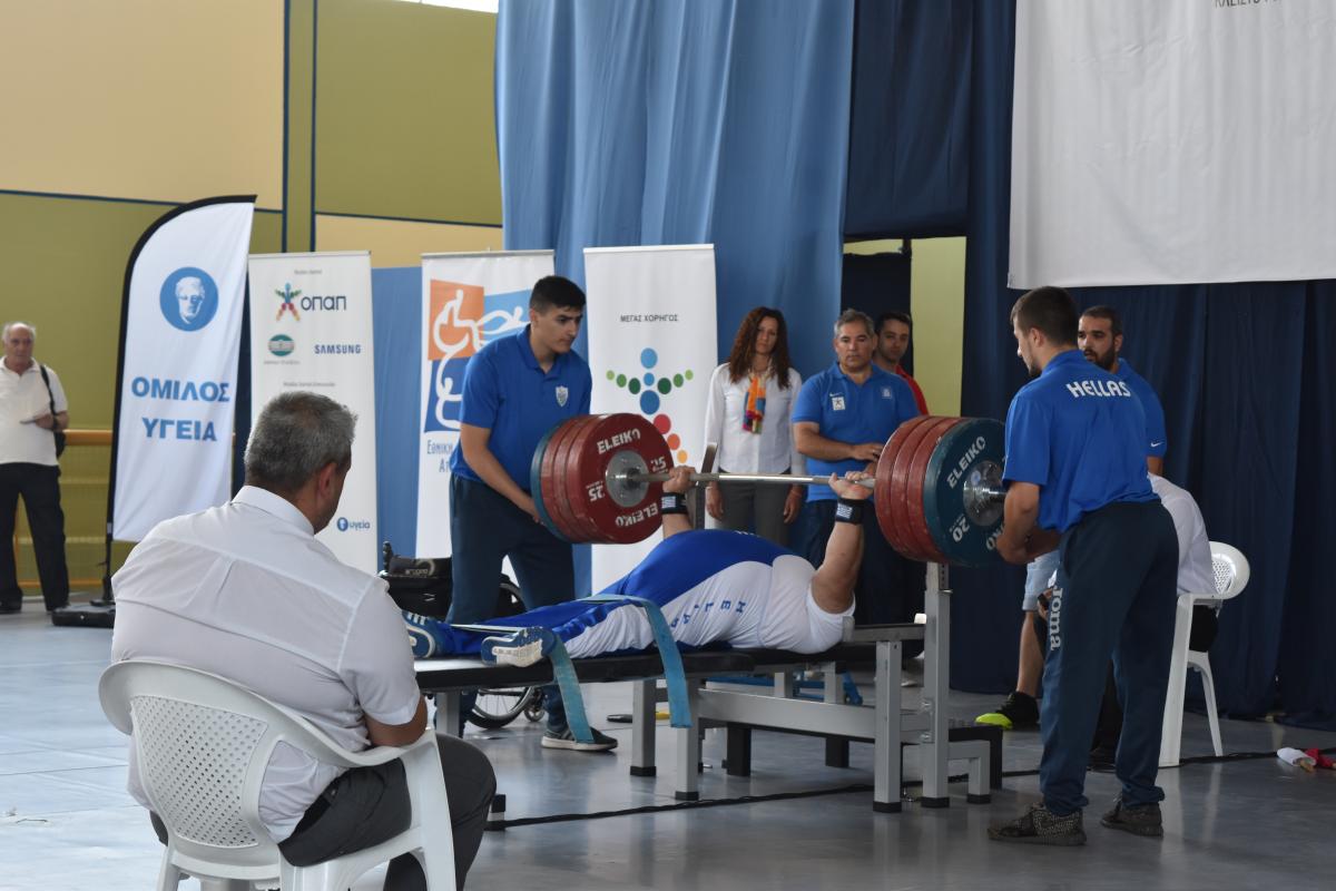 man powerlifting weights on bench