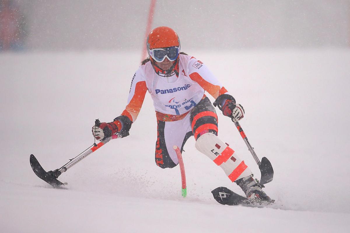 female alpine skier slaloms through gate